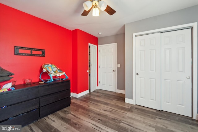 bedroom with ceiling fan, a closet, and wood-type flooring