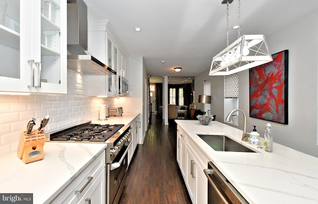 kitchen with white cabinets, appliances with stainless steel finishes, wall chimney exhaust hood, and sink