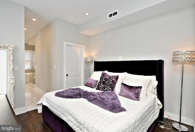 bedroom featuring dark wood-type flooring and ensuite bath