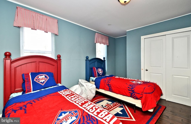 bedroom with dark wood-type flooring and a closet