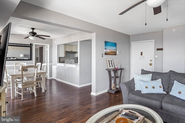 living room featuring ceiling fan, a textured ceiling, baseboards, and dark wood-style flooring