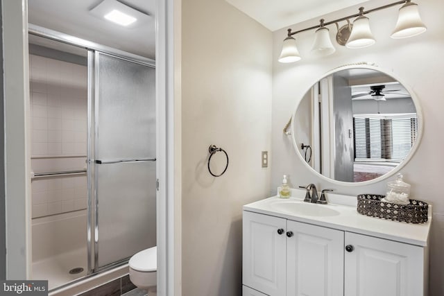 full bath with ceiling fan, vanity, toilet, and an enclosed shower