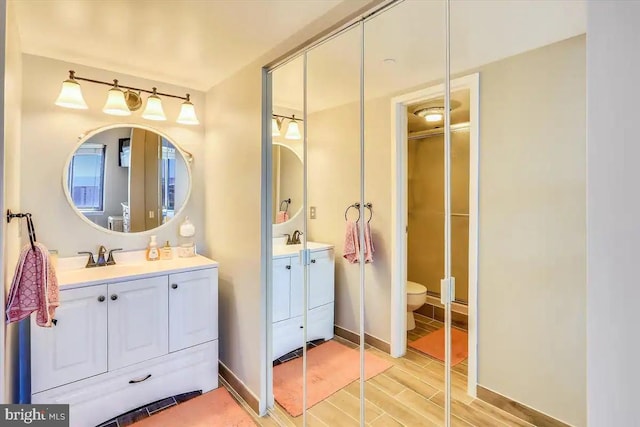 full bathroom featuring vanity, toilet, and wood finished floors