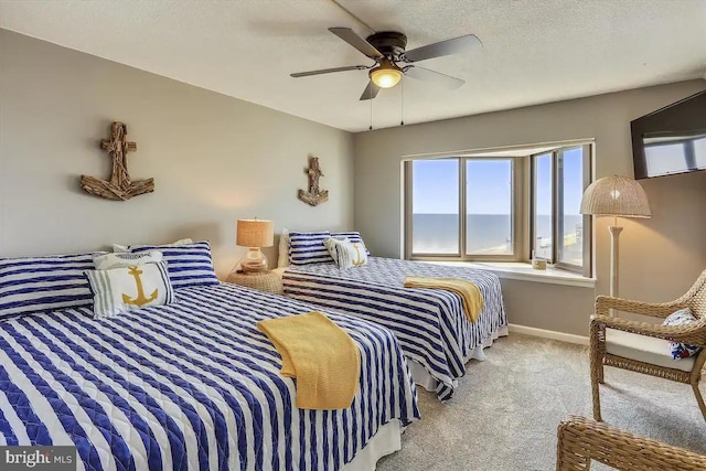 bedroom featuring a ceiling fan, light colored carpet, a textured ceiling, and baseboards