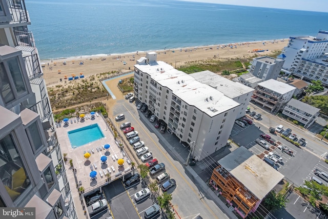 birds eye view of property with a water view and a beach view