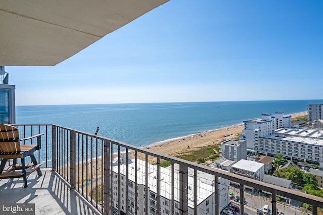 balcony featuring a view of the beach and a water view