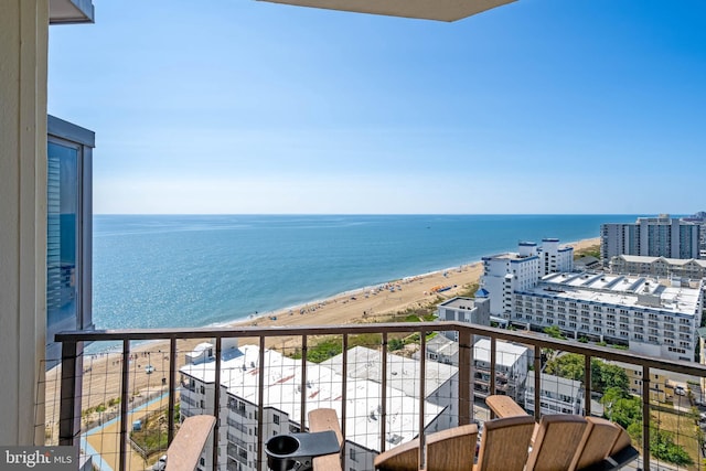 balcony featuring a view of the beach, a water view, and a city view