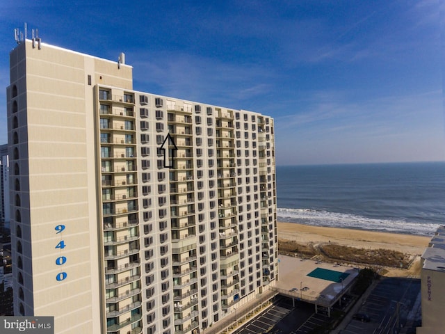 view of property with a water view and a beach view