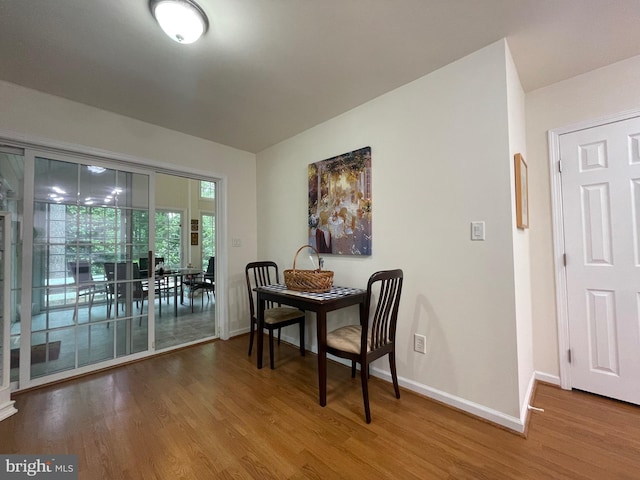 dining area with baseboards and wood finished floors