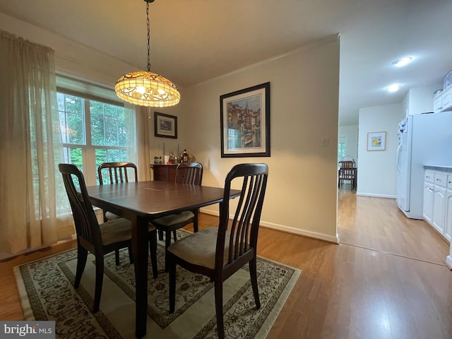 dining area with baseboards and light wood-style floors