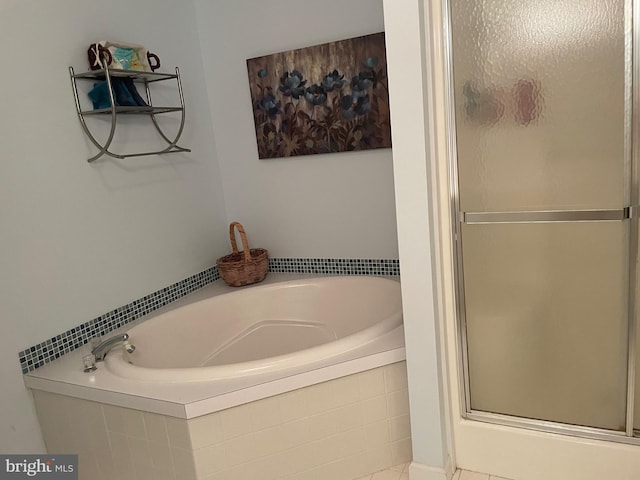 bathroom featuring a garden tub and a shower stall