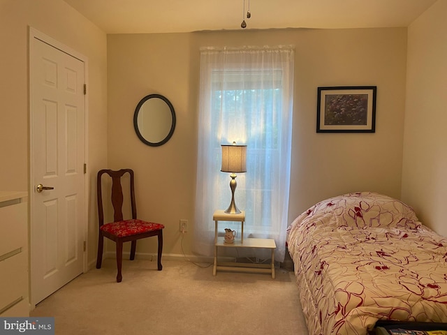 bedroom with light colored carpet and baseboards