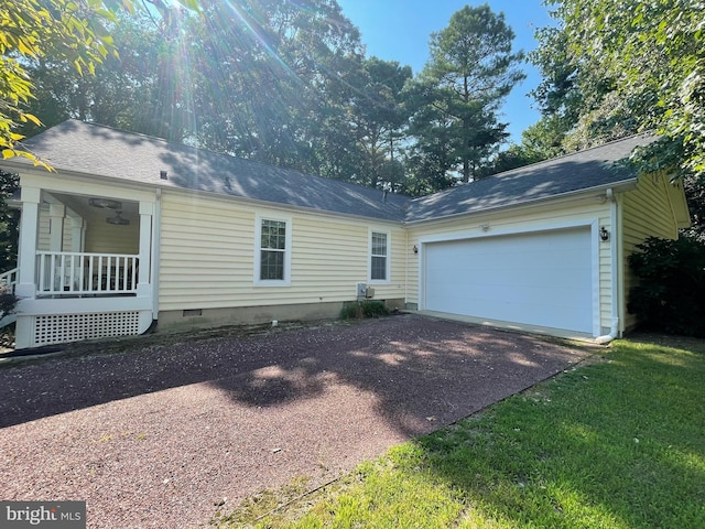 ranch-style home with a garage, a front yard, and a porch