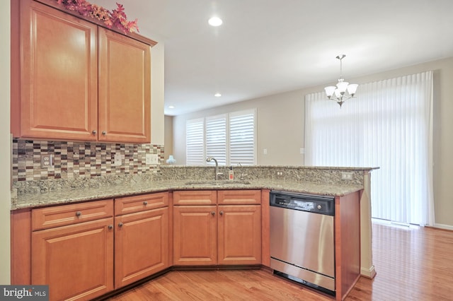 kitchen featuring light wood-type flooring, sink, stainless steel dishwasher, and light stone counters