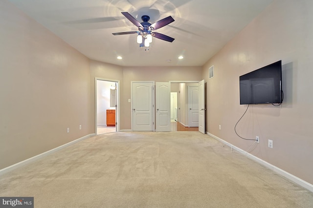 unfurnished bedroom with light carpet, ensuite bath, and ceiling fan