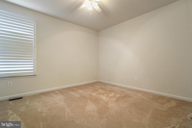 spare room featuring ceiling fan and light colored carpet