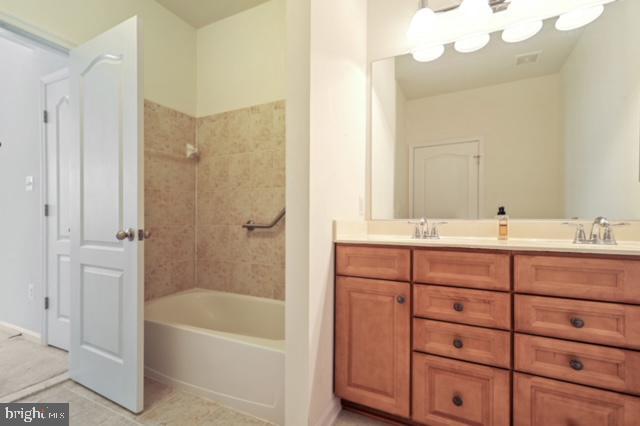 bathroom with vanity, tile patterned floors, and tiled shower / bath