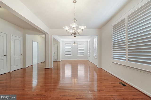 interior space featuring hardwood / wood-style flooring and an inviting chandelier