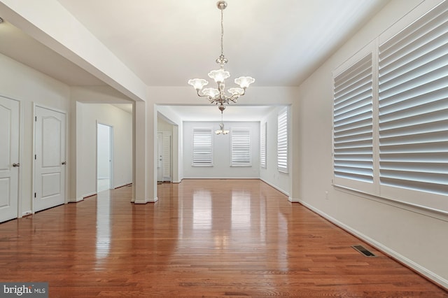 foyer entrance with wood-type flooring and a chandelier