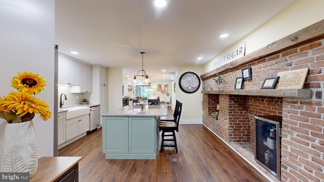 kitchen with white cabinets, stainless steel dishwasher, a kitchen island, and dark hardwood / wood-style flooring