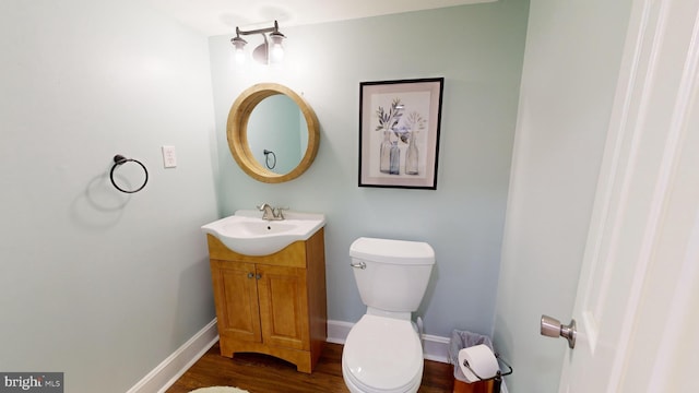 bathroom with vanity, toilet, and hardwood / wood-style floors