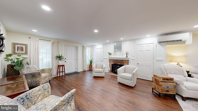 living room with dark wood-type flooring and a wall mounted AC