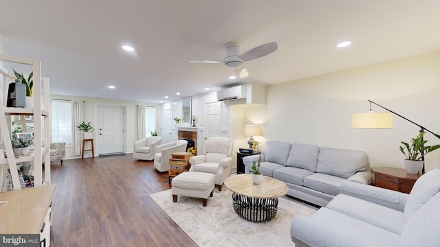 living room with ceiling fan, a wall mounted air conditioner, and hardwood / wood-style floors