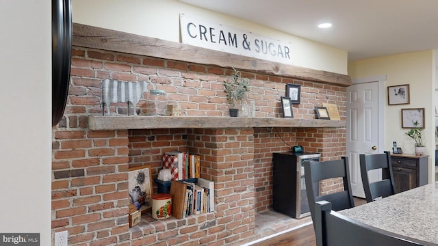 interior space featuring wood-type flooring and brick wall