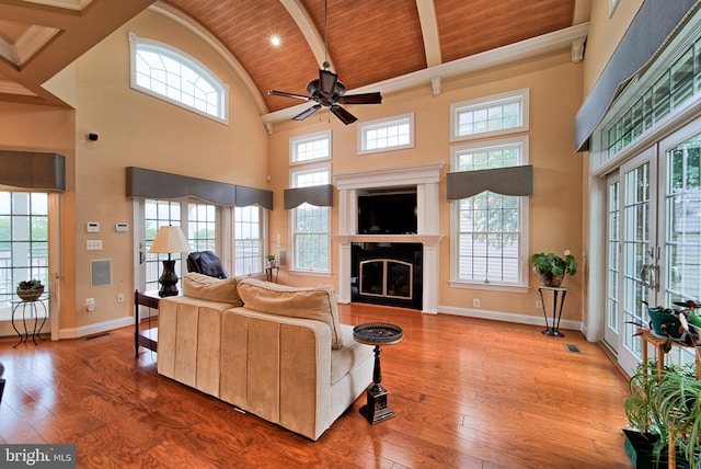 living area featuring light wood-type flooring, wood ceiling, a fireplace, and baseboards