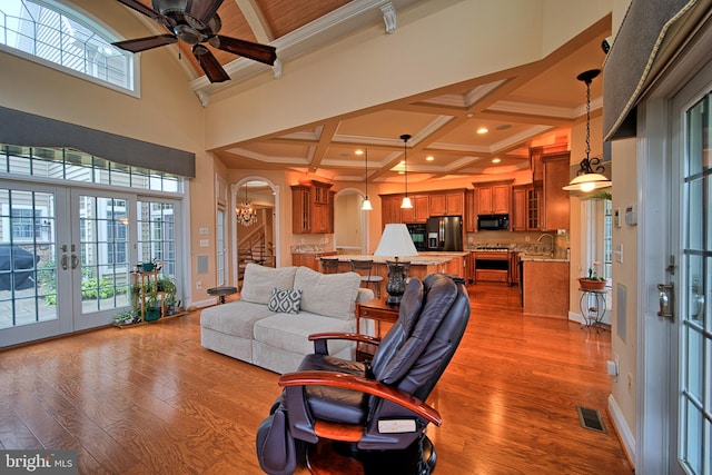 living area with plenty of natural light, stairway, visible vents, and arched walkways