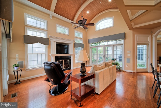 living room featuring baseboards, visible vents, a glass covered fireplace, wooden ceiling, and wood finished floors