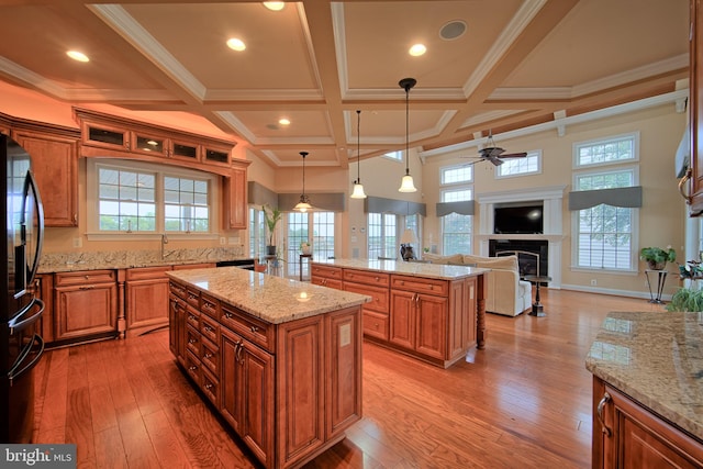 kitchen featuring brown cabinetry, freestanding refrigerator, pendant lighting, and a kitchen island