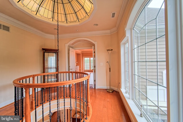 hall with arched walkways, visible vents, and wood finished floors