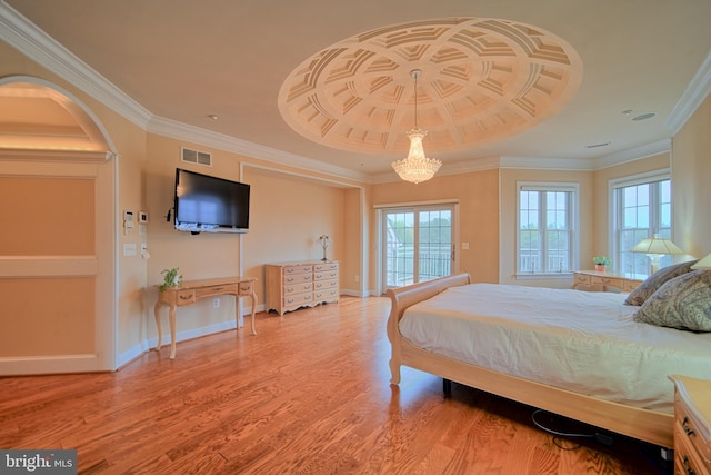 bedroom featuring wood finished floors, visible vents, baseboards, access to outside, and a tray ceiling