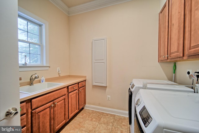 laundry room with cabinet space, ornamental molding, a sink, washer and dryer, and baseboards