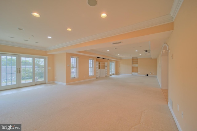 spare room featuring french doors, plenty of natural light, visible vents, and light colored carpet