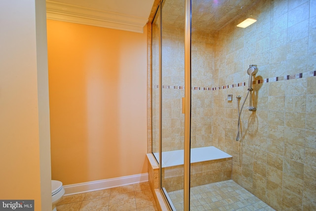 full bathroom with baseboards, tiled shower, toilet, tile patterned flooring, and crown molding