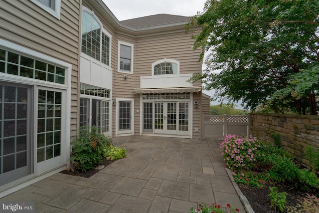 rear view of house featuring french doors, a patio, and fence