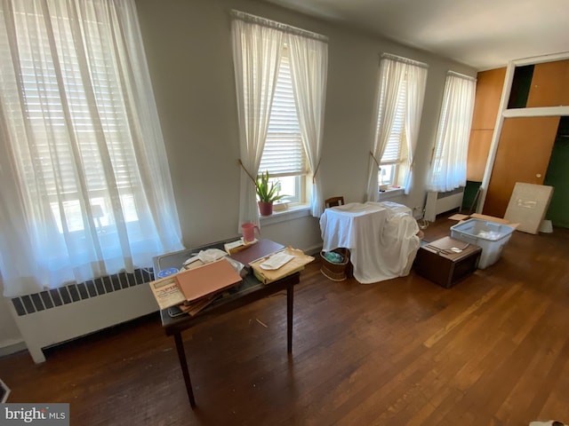 interior space with radiator and hardwood / wood-style flooring