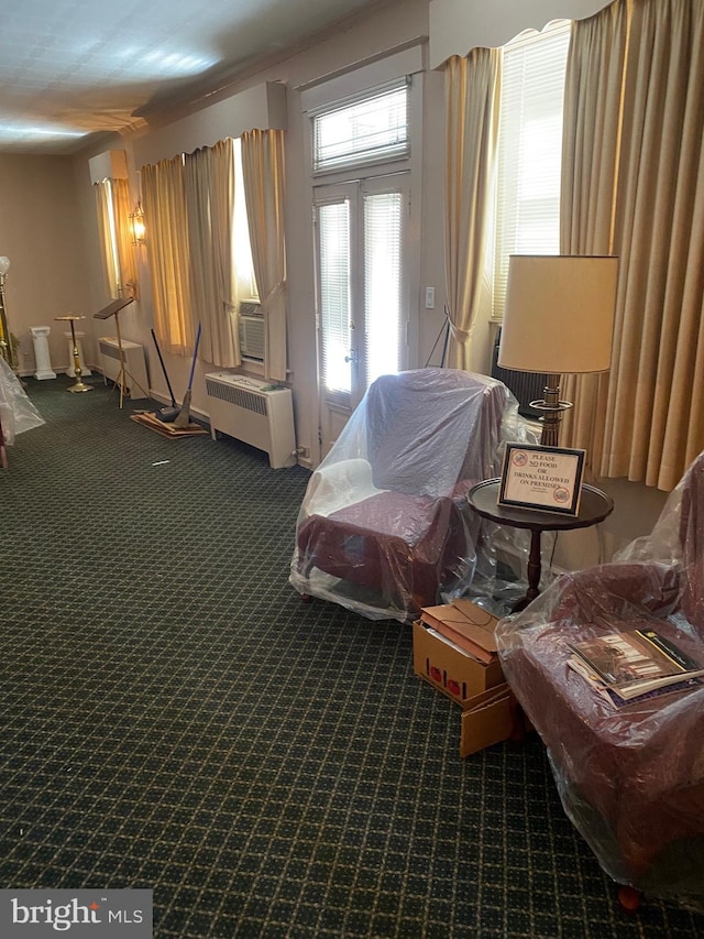 sitting room with french doors, radiator, and dark colored carpet