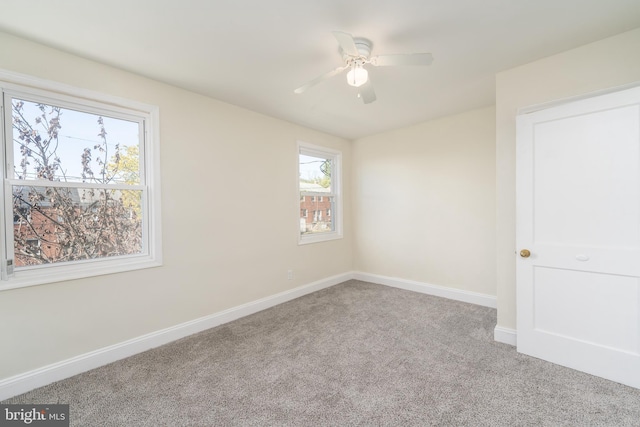 carpeted spare room featuring ceiling fan