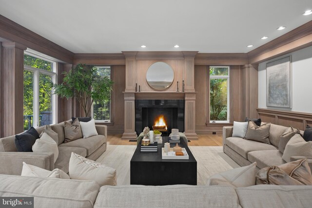 living room with light wood-type flooring and ornamental molding