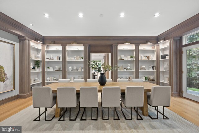 dining space featuring light wood-type flooring and ornamental molding