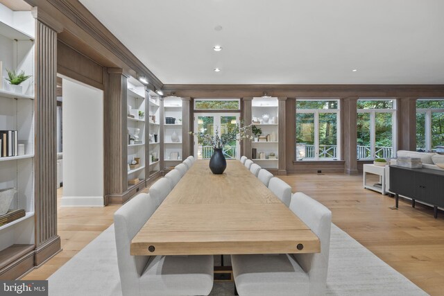 dining room with a wealth of natural light, french doors, light hardwood / wood-style floors, and ornamental molding