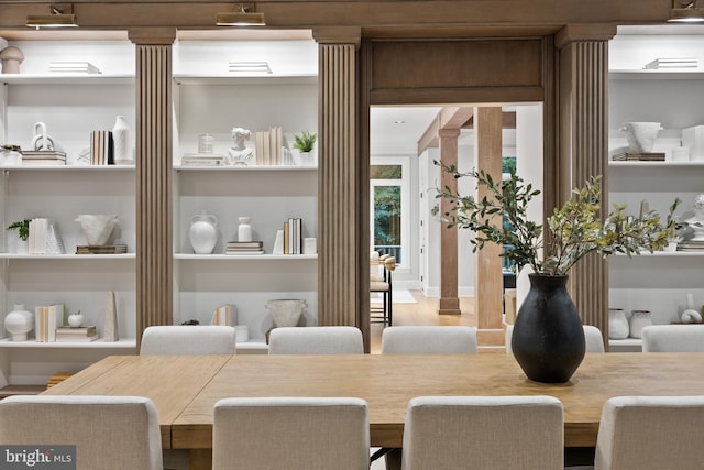 dining area featuring ornate columns, hardwood / wood-style flooring, and built in shelves