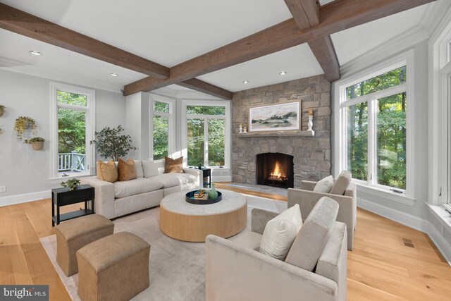 living room with a fireplace, beam ceiling, and light hardwood / wood-style floors