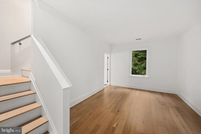 unfurnished room featuring light wood-type flooring and crown molding