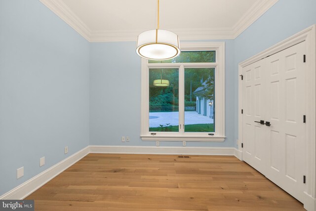 foyer featuring a healthy amount of sunlight, ornamental molding, and light wood-type flooring