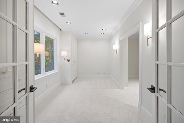 empty room with ornamental molding and light colored carpet