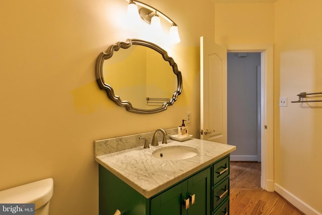 bathroom featuring vanity, hardwood / wood-style floors, and toilet